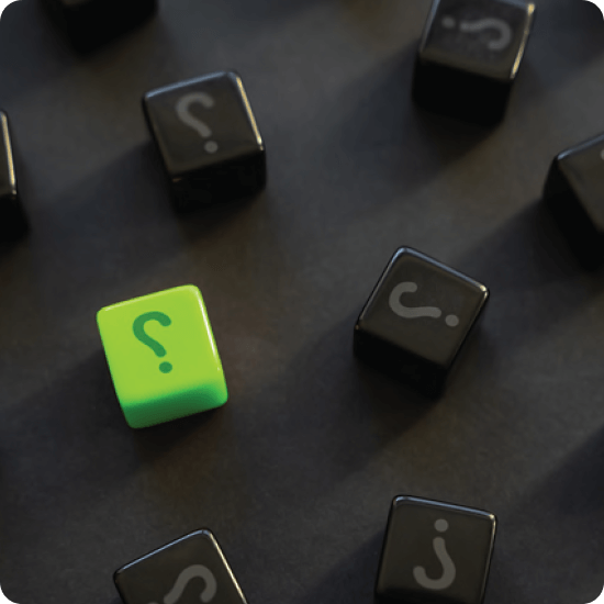 A single green question mark cube stands out among numerous black question mark cubes on a dark surface